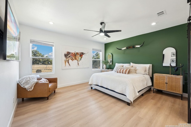 bedroom featuring multiple windows, light wood-type flooring, and ceiling fan