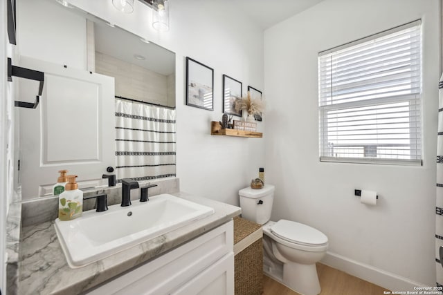 bathroom featuring vanity, curtained shower, plenty of natural light, and toilet