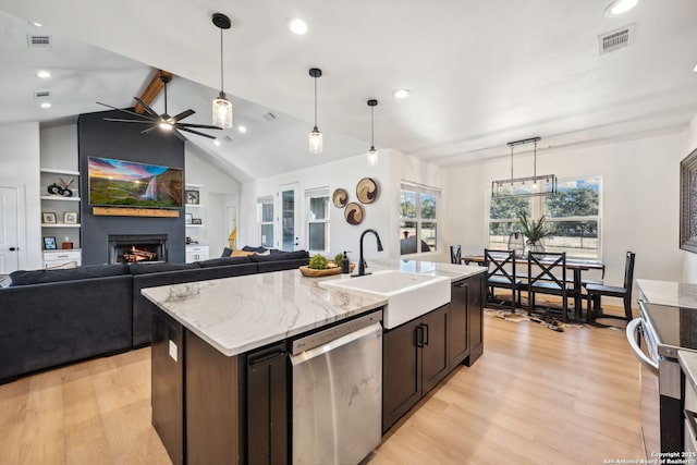 kitchen featuring sink, hanging light fixtures, lofted ceiling with beams, an island with sink, and stainless steel dishwasher