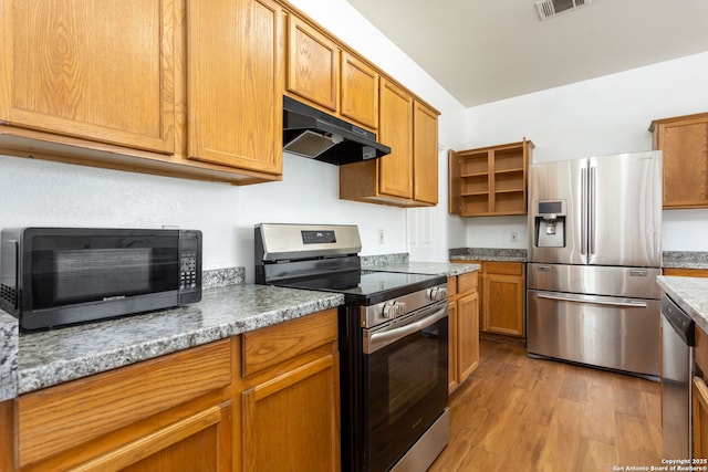 kitchen with light stone counters, stainless steel appliances, and light wood-type flooring