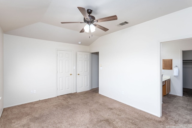 unfurnished bedroom with lofted ceiling, connected bathroom, carpet floors, and ceiling fan