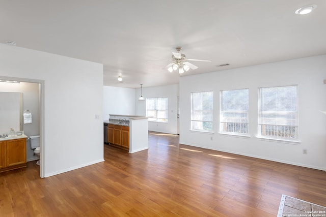 unfurnished living room featuring dark hardwood / wood-style floors and ceiling fan