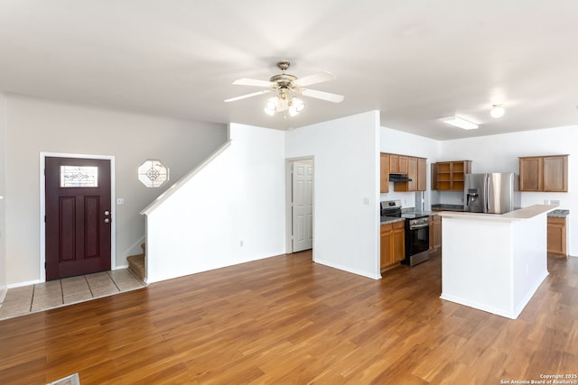 kitchen featuring ceiling fan, appliances with stainless steel finishes, a center island, and light hardwood / wood-style floors