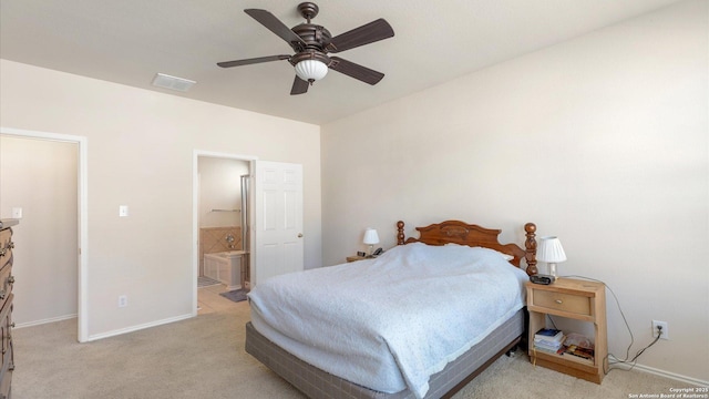 bedroom featuring ceiling fan, light colored carpet, and ensuite bath