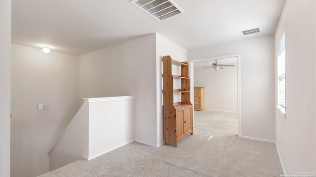 corridor with a wealth of natural light and light colored carpet