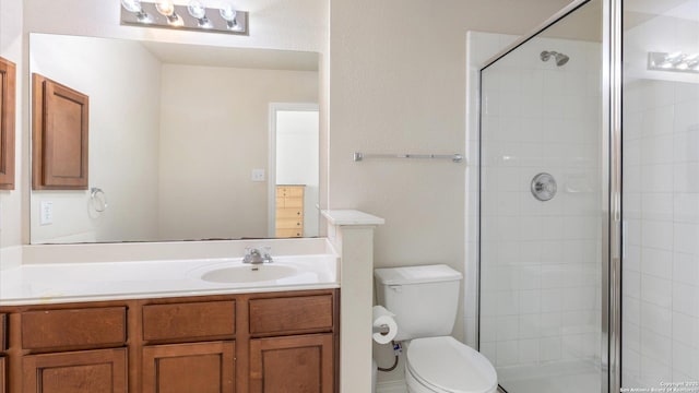 bathroom featuring vanity, toilet, and walk in shower