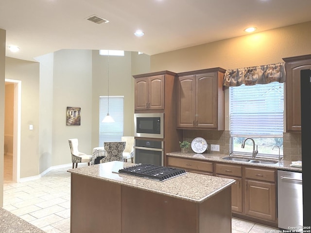 kitchen with sink, light tile patterned floors, backsplash, stainless steel appliances, and light stone counters