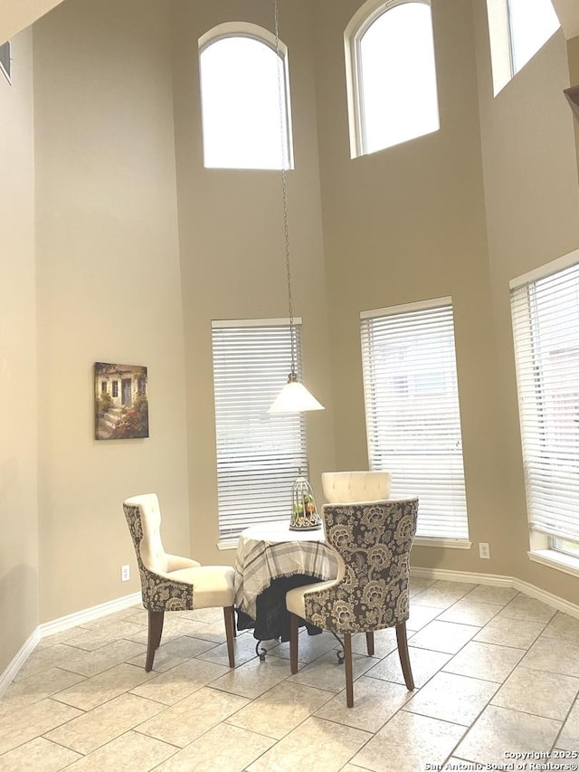 tiled dining room with a high ceiling