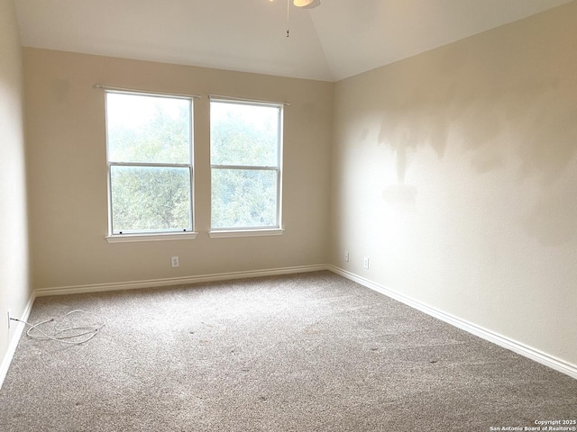 spare room with carpet floors and vaulted ceiling