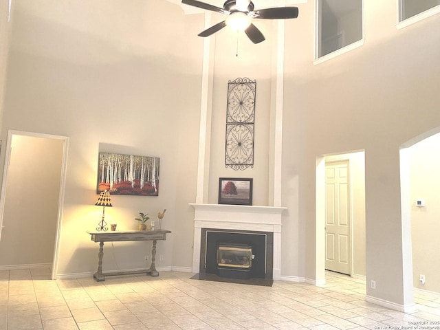 living room featuring a towering ceiling and ceiling fan