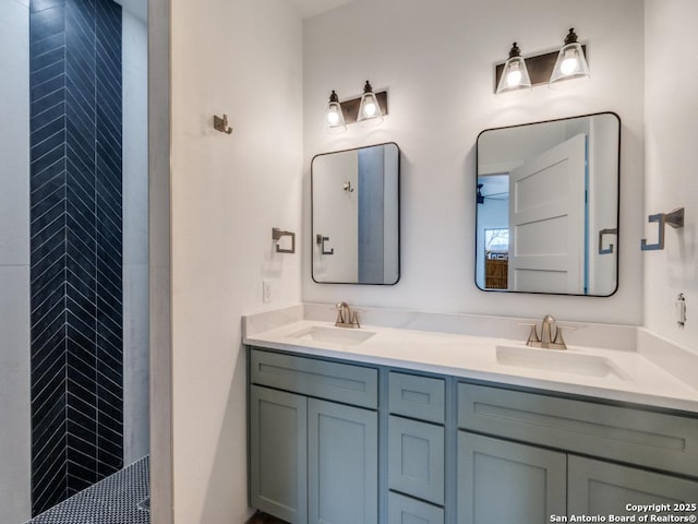 bathroom with tiled shower and vanity