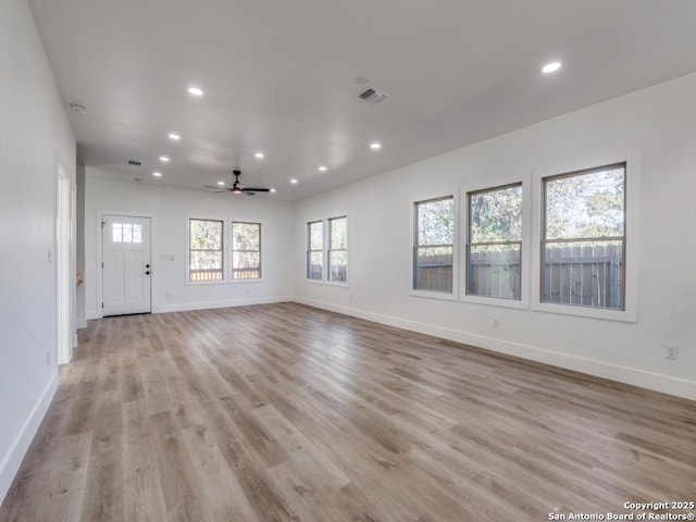 empty room with ceiling fan and light hardwood / wood-style floors