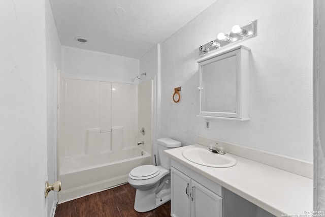 full bathroom with wood-type flooring, toilet,  shower combination, and vanity