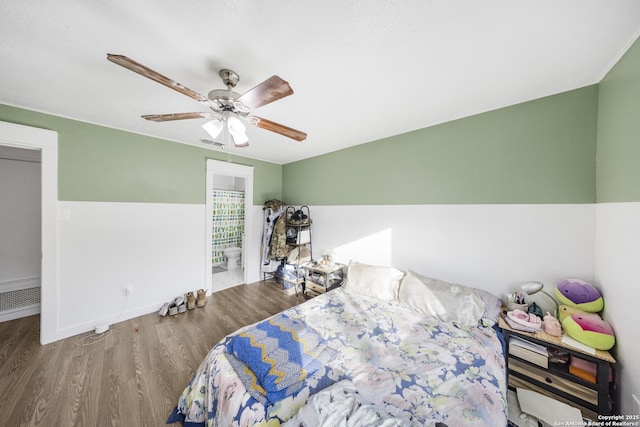 bedroom with ensuite bathroom, hardwood / wood-style floors, and ceiling fan