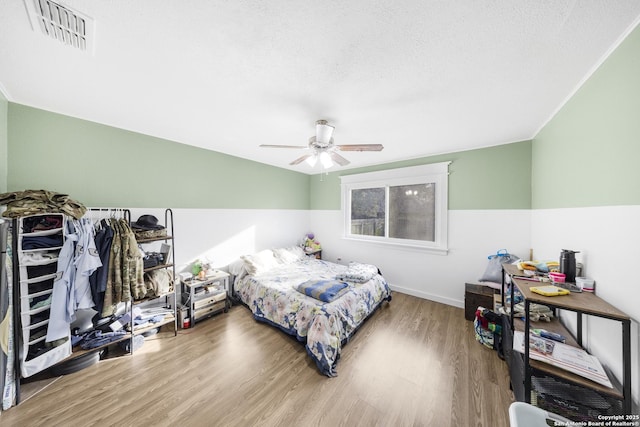 bedroom featuring hardwood / wood-style flooring, a textured ceiling, and ceiling fan