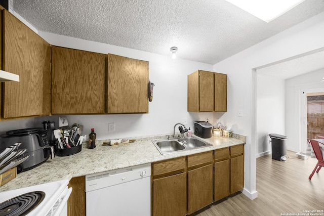 kitchen featuring white appliances, light hardwood / wood-style floors, sink, and a textured ceiling