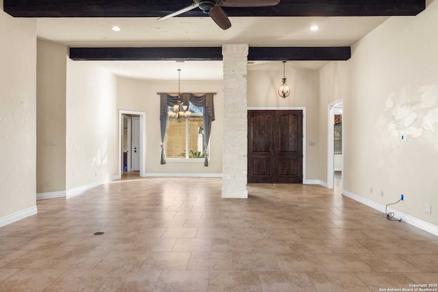 entryway with beamed ceiling, ceiling fan with notable chandelier, and decorative columns