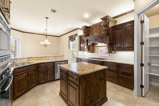 kitchen featuring dark brown cabinetry, sink, decorative light fixtures, a center island, and stainless steel appliances