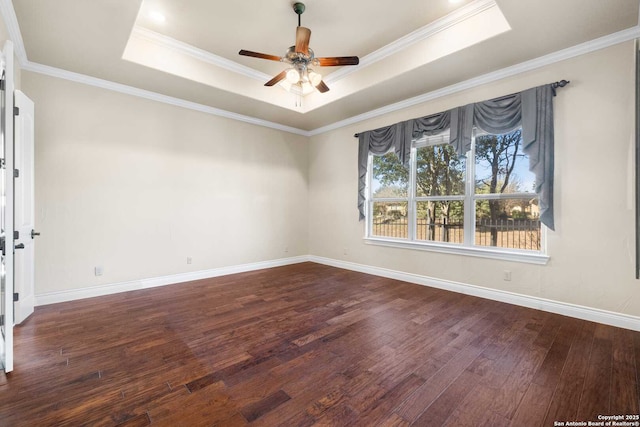 empty room featuring crown molding, ceiling fan, dark hardwood / wood-style floors, and a raised ceiling