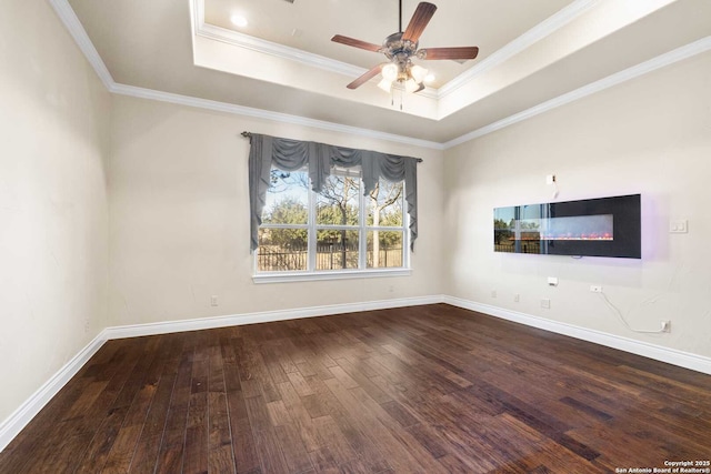 spare room with crown molding, hardwood / wood-style floors, a tray ceiling, and ceiling fan