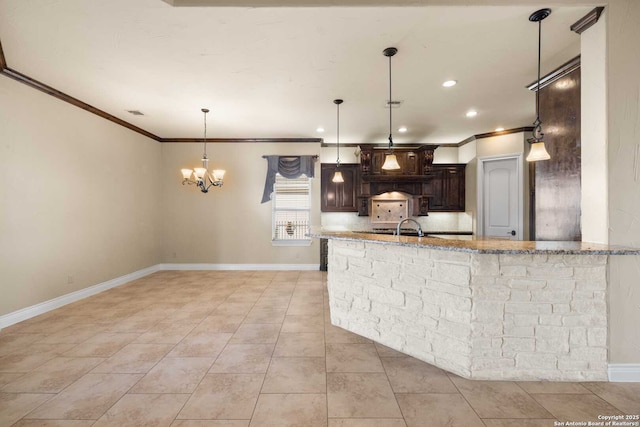 kitchen featuring hanging light fixtures, crown molding, light stone countertops, and dark brown cabinets