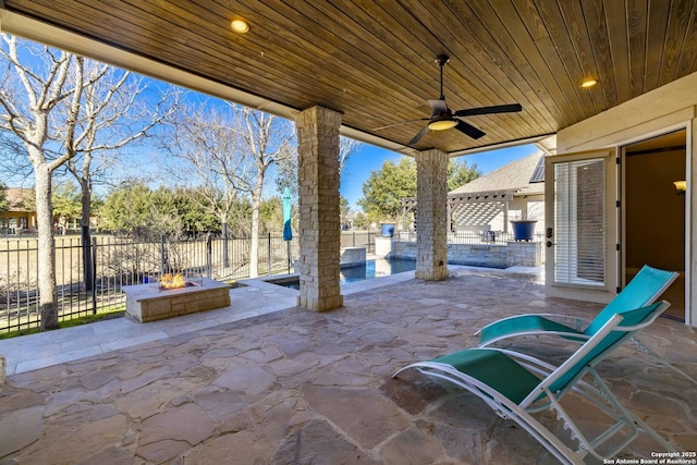 view of patio / terrace featuring a pool, ceiling fan, and a fire pit