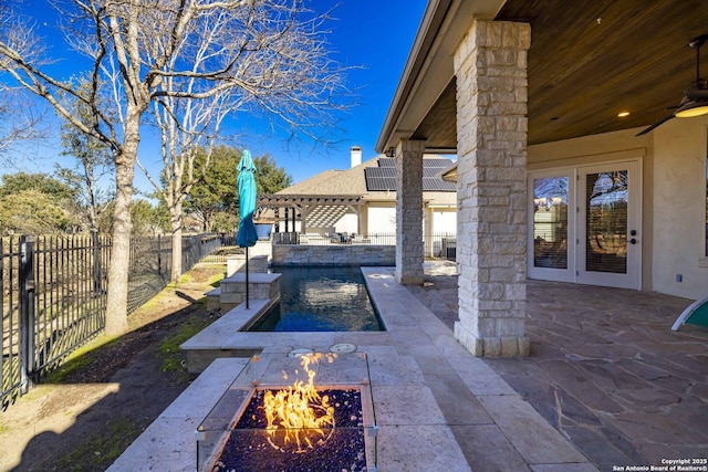 view of patio featuring a fire pit, ceiling fan, and french doors