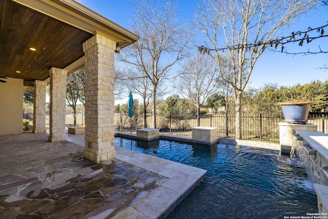 view of pool featuring a patio, pool water feature, and an outdoor bar