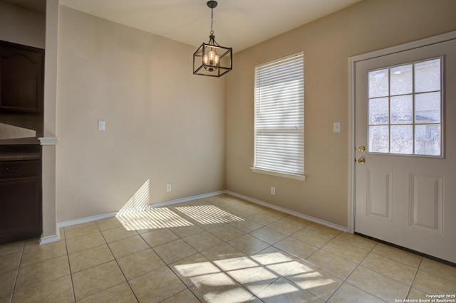 unfurnished dining area with light tile patterned floors and a notable chandelier