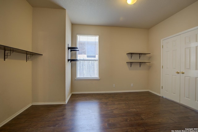 unfurnished bedroom featuring dark wood-type flooring and a closet