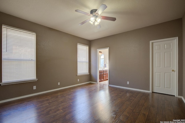 empty room with dark wood-type flooring and ceiling fan