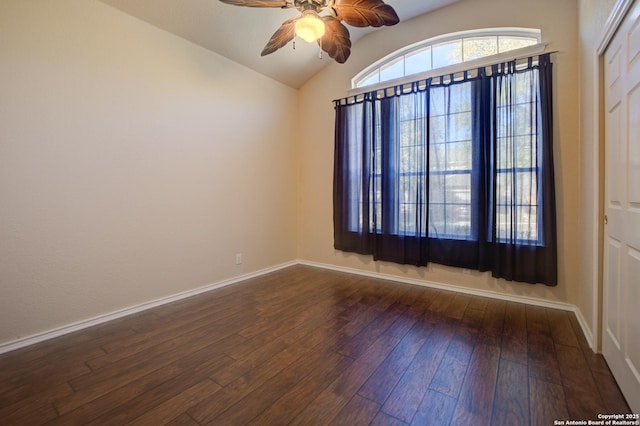 empty room with vaulted ceiling, dark hardwood / wood-style floors, and ceiling fan