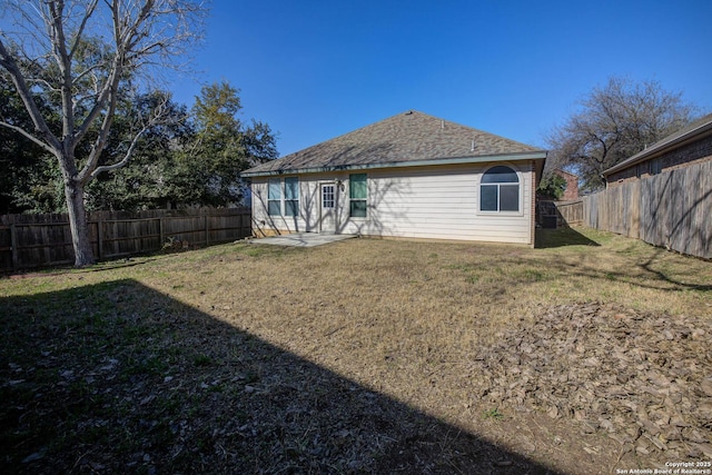 rear view of property featuring a lawn