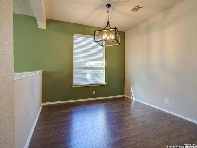 unfurnished dining area with dark hardwood / wood-style floors and a chandelier