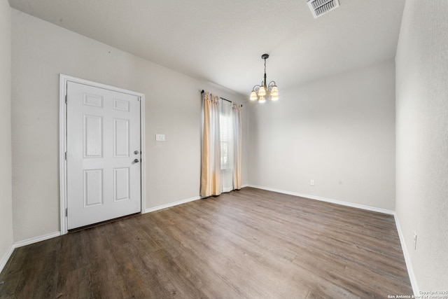 unfurnished room with hardwood / wood-style flooring and a chandelier