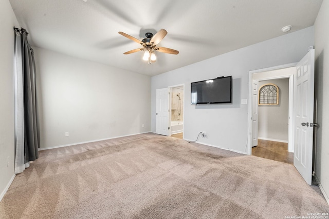 unfurnished bedroom featuring ceiling fan, ensuite bath, and light carpet