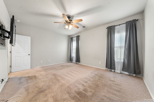 spare room with ceiling fan and carpet