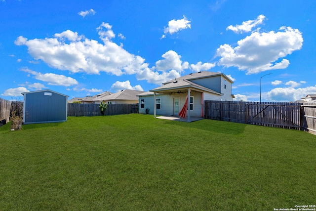 rear view of house featuring a patio, a lawn, and a shed