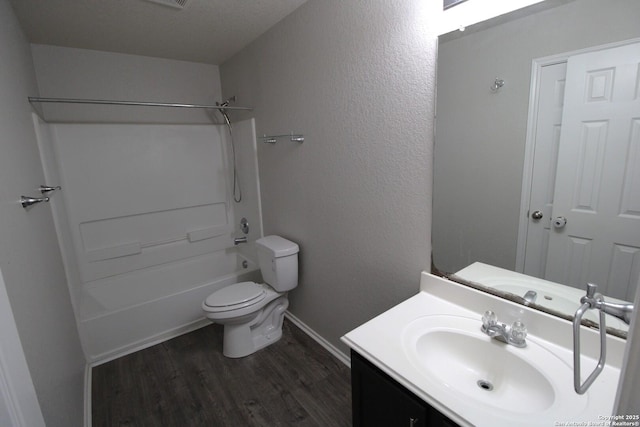 full bathroom with shower / bathtub combination, wood-type flooring, vanity, toilet, and a textured ceiling