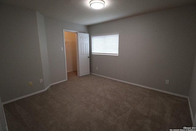 empty room with dark colored carpet