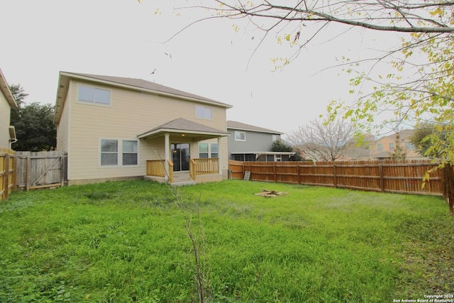 rear view of house featuring a yard