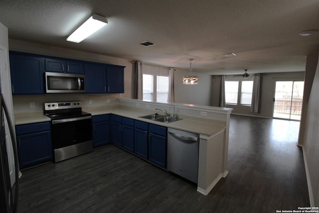 kitchen featuring blue cabinets, sink, appliances with stainless steel finishes, kitchen peninsula, and pendant lighting