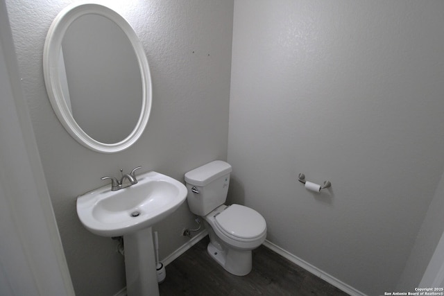 bathroom featuring hardwood / wood-style flooring, toilet, and sink