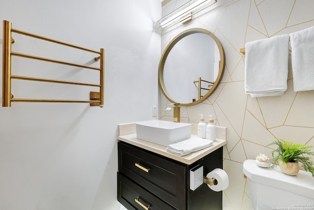 bathroom with vanity, tile walls, and toilet