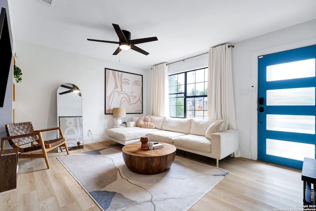 living room featuring light hardwood / wood-style flooring and ceiling fan