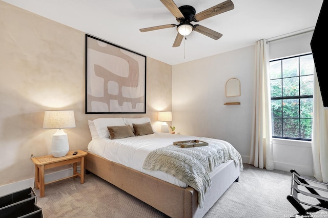 carpeted bedroom featuring ceiling fan and multiple windows