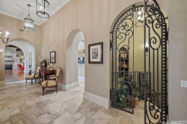 hallway with a high ceiling, crown molding, and a chandelier