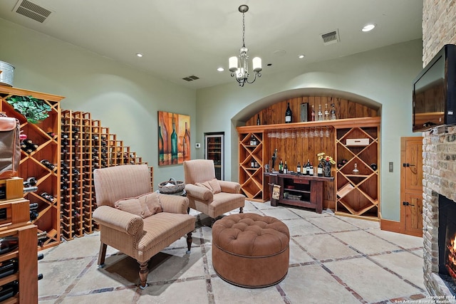 wine cellar with an inviting chandelier and a brick fireplace