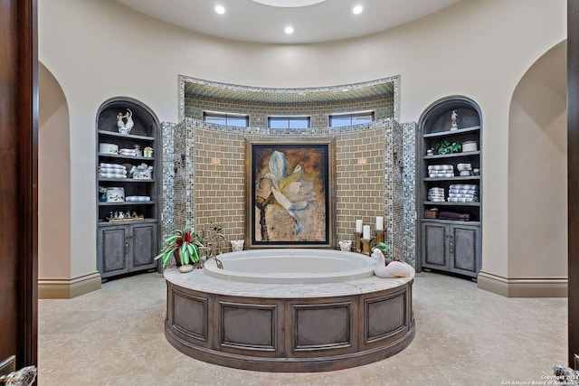 bathroom with a bathtub and built in features