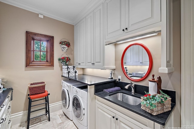 clothes washing area featuring cabinets, ornamental molding, sink, and independent washer and dryer